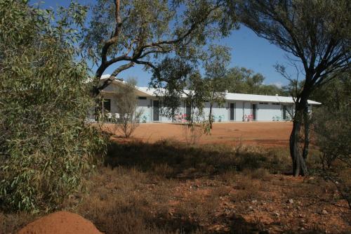 a white building in the middle of a field at Cooper's Country Lodge in Eromanga