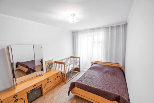 Schlafzimmer mit einem Bett und einem Spiegel in der Unterkunft Apartment on Polevaya 44/12 in Bohuslav