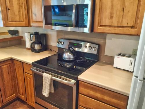 a kitchen with a stove and a microwave at Right on Main St Hot Tub Close to Marina Garage in Frisco