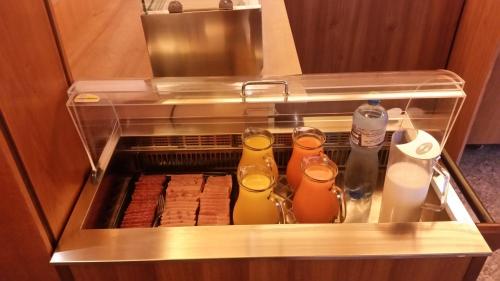 an open refrigerator with drinks in it at Motel des Sports Martigny in Martigny-Ville