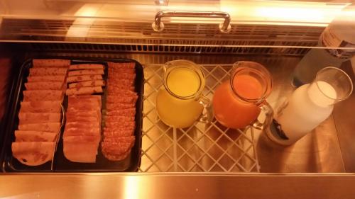a tray of sausages and two glasses of milk at Motel des Sports Martigny in Martigny-Ville