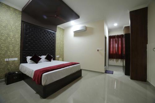 a bedroom with a large bed with a red curtain at Shivalaya Residency in Trichūr
