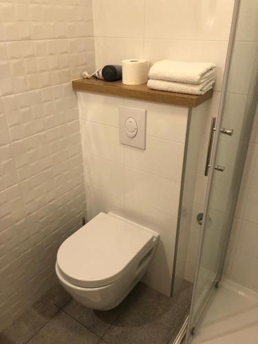 a bathroom with a toilet and towels on a shelf at Guest House Marija in Bol