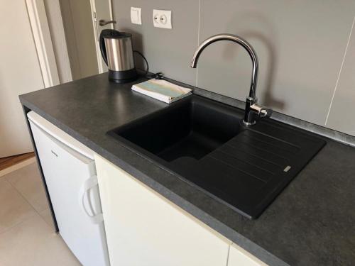 a kitchen counter with a black sink in a kitchen at Guest House Marija in Bol