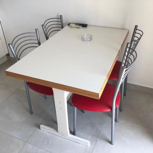 a table and chairs with a white table and red chairs at Guest House Marija in Bol