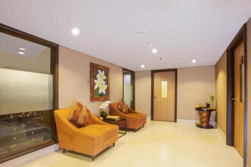 a living room with two chairs and a fireplace at de Vins Sky Hotel Seminyak in Seminyak