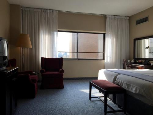 a hotel room with a bed and a chair and a window at The Royal Hotel by Coastlands Hotels & Resorts in Durban
