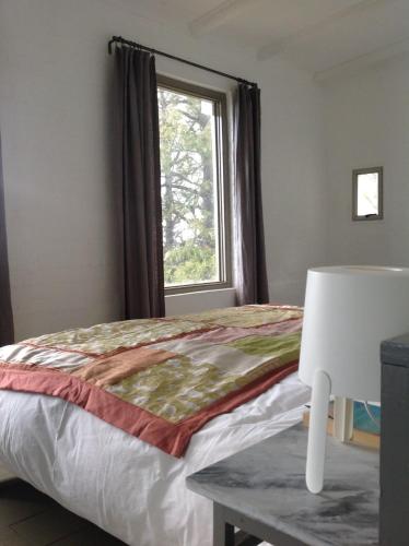 a bedroom with a bed with a window and a table at Kleinkloof Farm in Piketberg