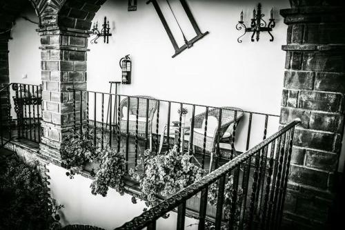 a black and white photo of a staircase with flowers at Hotel Rural Andalucia in Sierra de Yeguas