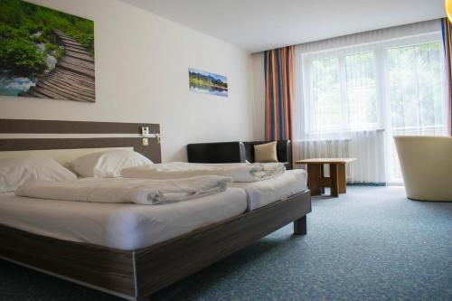 a hotel room with two beds and a table at Gasthof zur Wachau in Hofarnsdorf