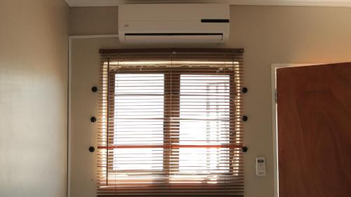 a window in a room with a air conditioner at Tap's Home Away from Home in Gaborone