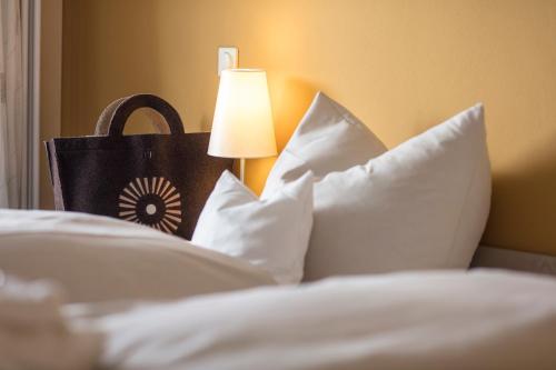 a bed with white pillows and a lamp with a purse at Schwarzwald Panorama in Bad Herrenalb