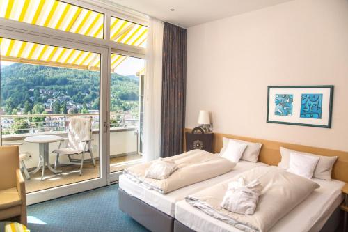 a hotel room with a bed and a balcony at Schwarzwald Panorama in Bad Herrenalb