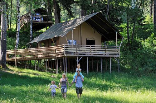 a man and two children walking in front of a house at Ferienparadies Natterer See in Innsbruck