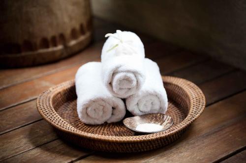 a basket with towels and a spoon on a table at Pacific Resort Aitutaki - Adults Only in Arutanga