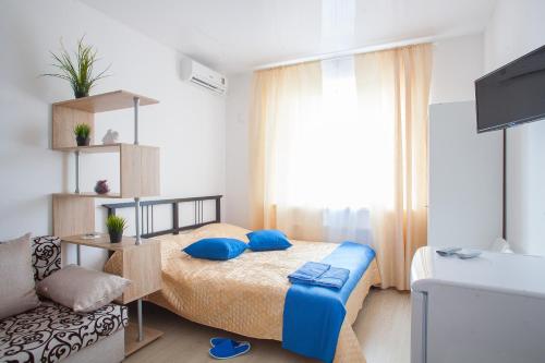 クラスノダールにあるМЕГА Апартаментыのベッドルーム1室(青い枕とソファ付)
