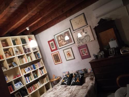 a bedroom with a bed and a book shelf with books at Room Garden in Padova