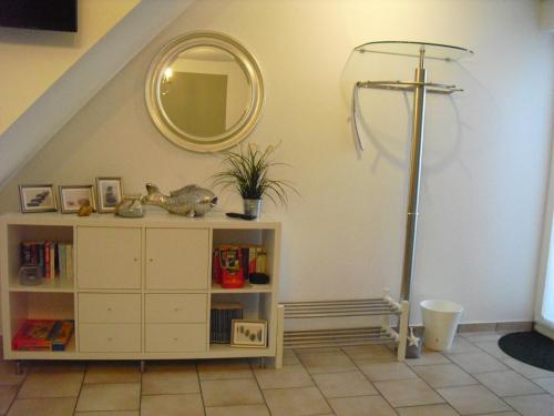 a room with a shelf with a cross and a mirror at Warnemünder Strandfieber in Rostock