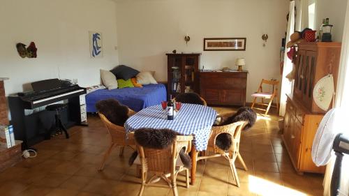 uma sala de estar com uma mesa, uma cama e um piano em Casa Belvedere em Mazzano Romano