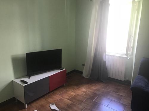 巴韋諾的住宿－Appartamento LA DULCE VIDA，客厅配有餐桌上的平面电视