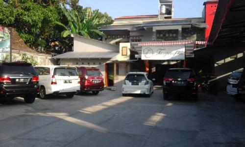 een groep auto's geparkeerd op een parkeerplaats bij Tanjung Inn in Wonosari
