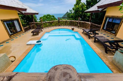 a swimming pool on a deck with a house at Haadson Resort & Koh Raham in Haad Son