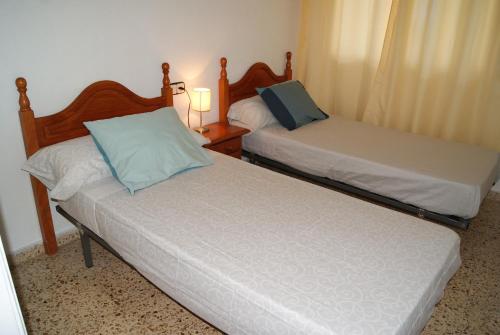 two twin beds in a room with two lamps at Playa Delicias in Águilas