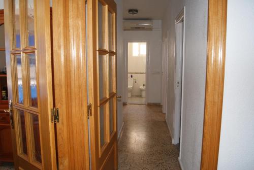a hallway with wooden doors and a bathroom with a toilet at Playa Delicias in Águilas