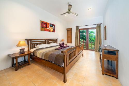 1 dormitorio con cama, mesa y ventana en Temple Gardens, en Bophut 