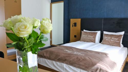 a bedroom with a bed with a vase of flowers at Tynset Hotel in Tynset