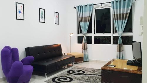 a living room with a black leather couch and a table at ArbarHome in Klang