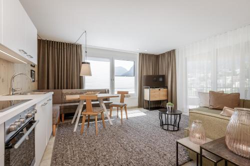 a kitchen and living room with a couch and a table at Apart am Sonnenhügel in Sautens