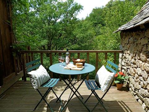 een tafel en twee stoelen op een terras met een tafel en stoelen bij Le Studio in Entraygues-sur-Truyère