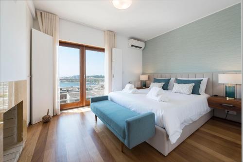a bedroom with a large bed and a large window at Atlantic House - Waterfront Luxury Home in Vila Nova de Gaia