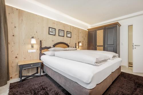 een slaapkamer met een groot bed en een houten muur bij Apart am Sonnenhügel in Sautens