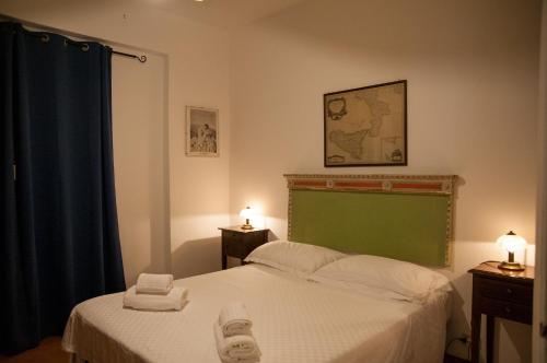 a bedroom with a bed with two towels on it at Mediterraneo Guesthouse in Giardini Naxos