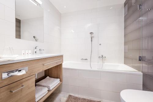 a bathroom with a tub and a shower and a sink at Apart am Sonnenhügel in Sautens