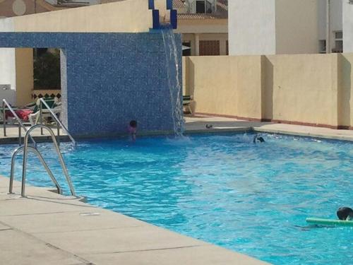 un niño en una piscina con una fuente de agua en Pueblo evita en Benalmádena