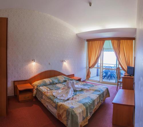 a hotel room with a bed and a window at Hotel Kristel Park - All Inclusive Light in Kranevo