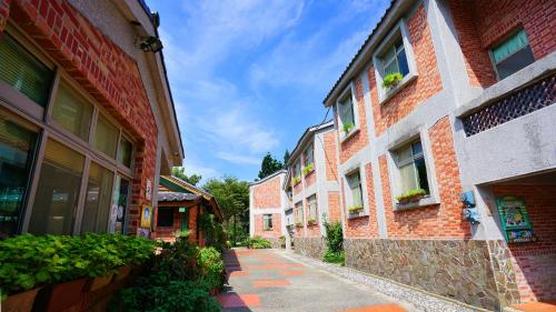 an alley way between two brick buildings with plants at Red Brick Villas in Nanzhuang
