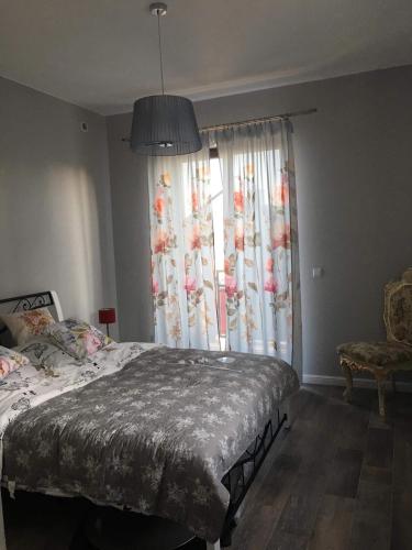 a bedroom with a bed and a large window at Rubinowe Apartamenty in Sandomierz