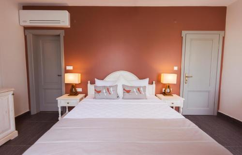 a bedroom with a large white bed with two tables at Kapya Cunda in Ayvalık