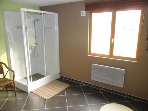 a bathroom with a shower with a window and a chair at le gite d'olhain in Fresnicourt-le-Dolmen