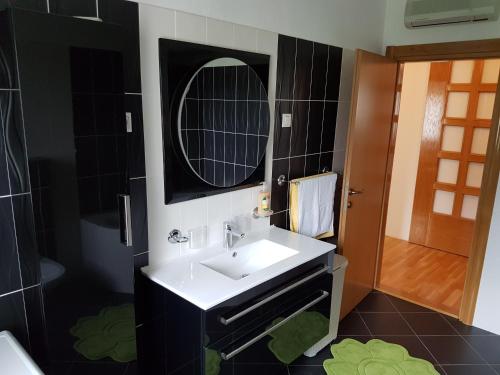 a bathroom with a white sink and a mirror at Stella Maris in Kaštela