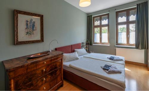 een slaapkamer met een bed, een dressoir en een wastafel bij Ferienwohnungen am Schloss in Lutherstadt Wittenberg
