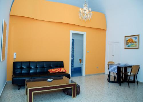 uma sala de estar com um sofá de couro preto e uma mesa em Casa Catalano em Terlizzi