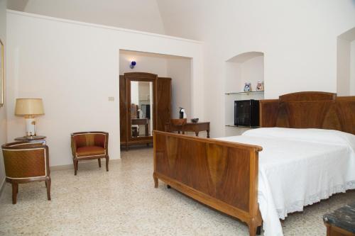 um quarto com uma grande cama e cadeiras de madeira em Casa Catalano em Terlizzi