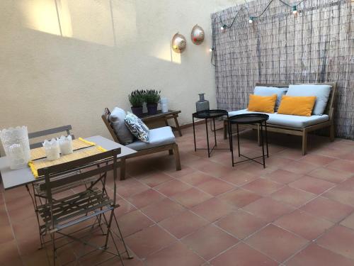 un patio con 2 sofás y mesas con almohadas naranjas en Le Studio des Artistes, en Marsella
