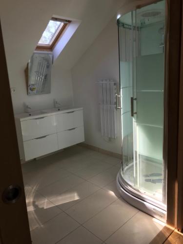 a bathroom with a glass shower and a sink at Le Loft in Lacanau