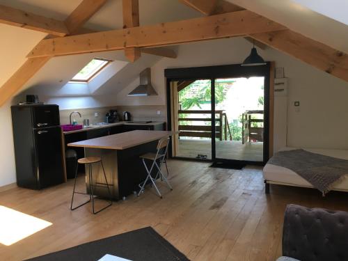 a kitchen and living room with a table and a bed at Le Loft in Lacanau